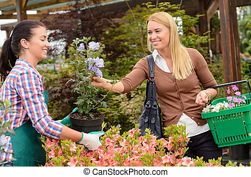 Garden center worker selling potted flower